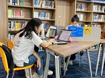 Học viên luyện thi MOS trên laptop tại thư viện